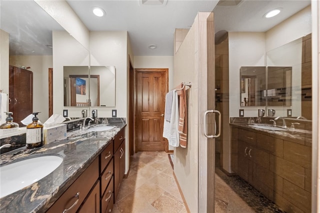 bathroom featuring double vanity, a stall shower, a sink, and recessed lighting