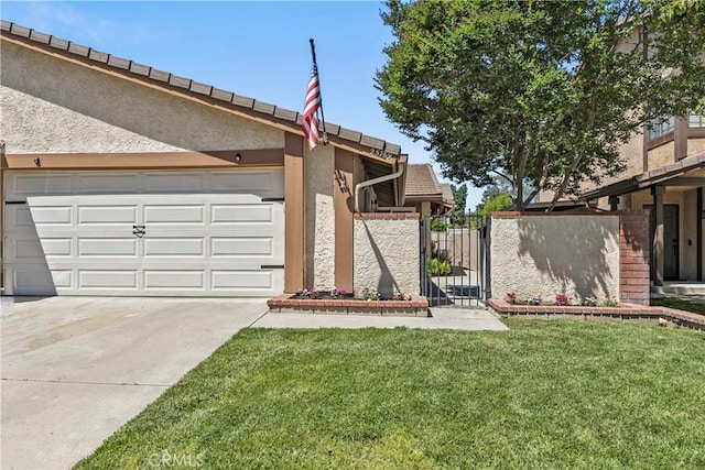 view of yard featuring a garage, a gate, and concrete driveway