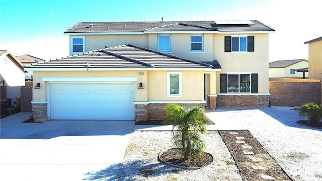 view of front facade with brick siding, stucco siding, solar panels, a garage, and driveway