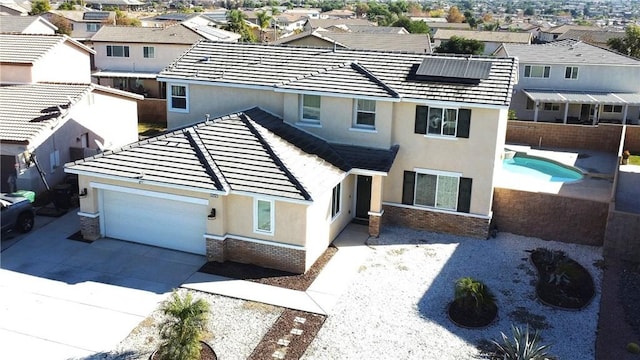 view of front of property with concrete driveway, roof mounted solar panels, a residential view, and stucco siding