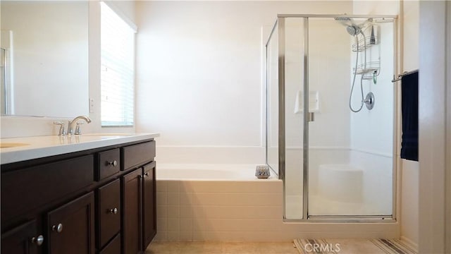 bathroom with a garden tub, double vanity, a sink, and a shower stall