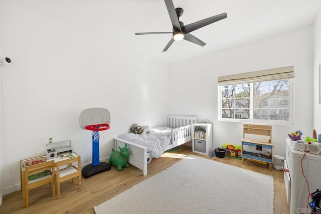 bedroom with wood finished floors, a ceiling fan, and baseboards