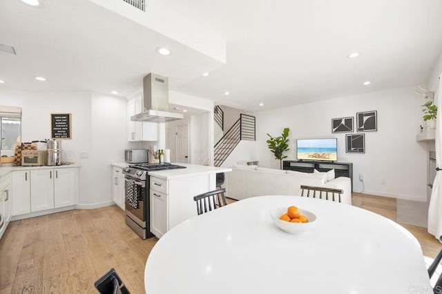 dining area featuring recessed lighting, visible vents, light wood-style flooring, baseboards, and stairs