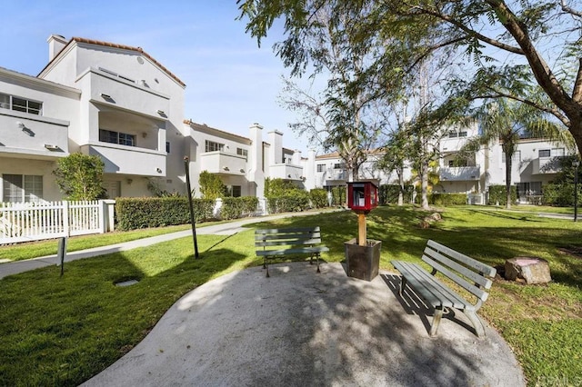 view of community featuring a patio area, a residential view, fence, and a yard