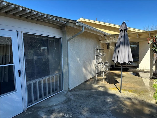 exterior space featuring a patio area and stucco siding