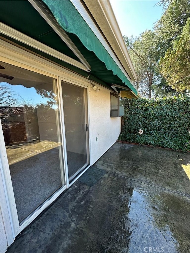 exterior space with stucco siding and a patio