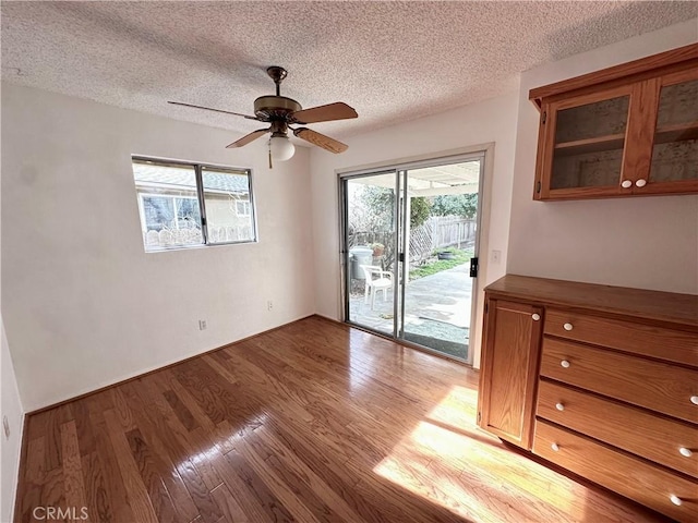 interior space with light wood-type flooring, ceiling fan, and a textured ceiling