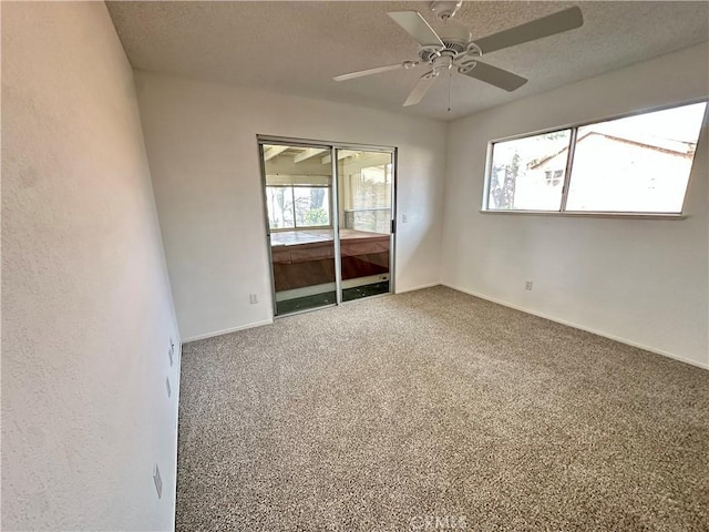 carpeted empty room with a wealth of natural light, ceiling fan, a textured ceiling, and baseboards