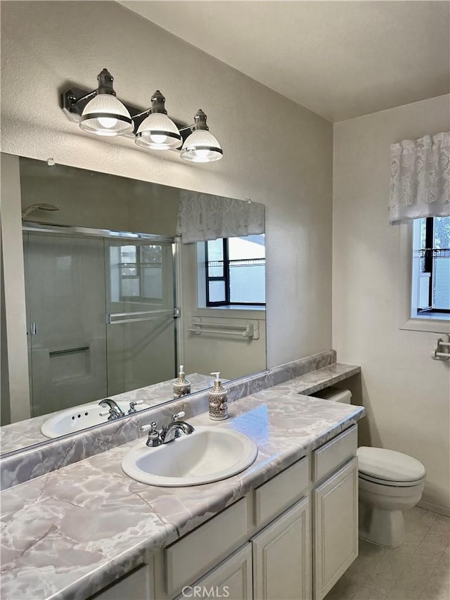 bathroom with a stall shower, vanity, and toilet