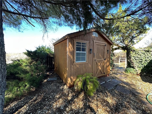 view of shed featuring fence