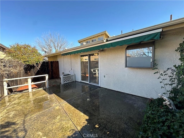 back of house featuring a patio area, fence, and stucco siding