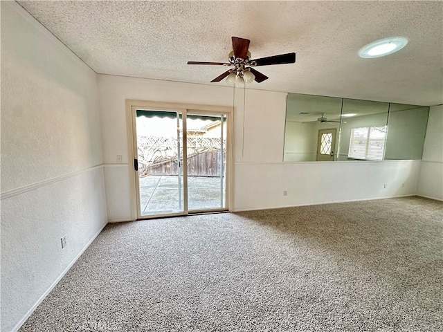 unfurnished room with a textured ceiling, a textured wall, carpet floors, and ceiling fan