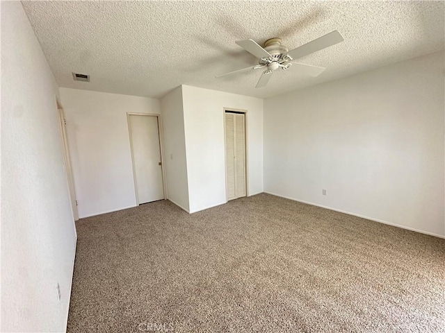 unfurnished bedroom with carpet floors, a closet, visible vents, and a ceiling fan