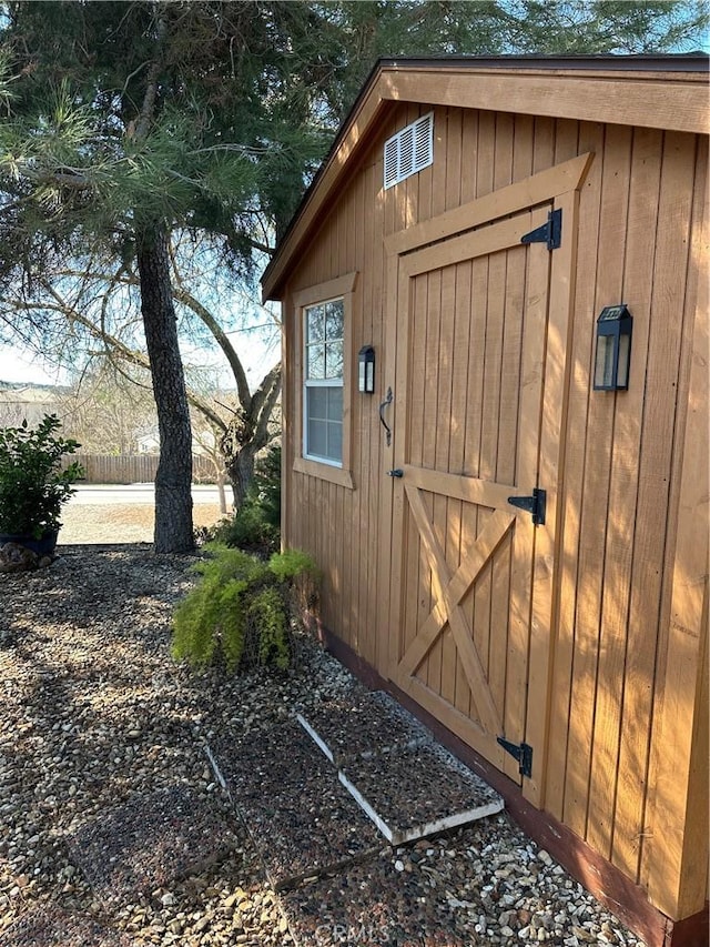 view of shed featuring fence