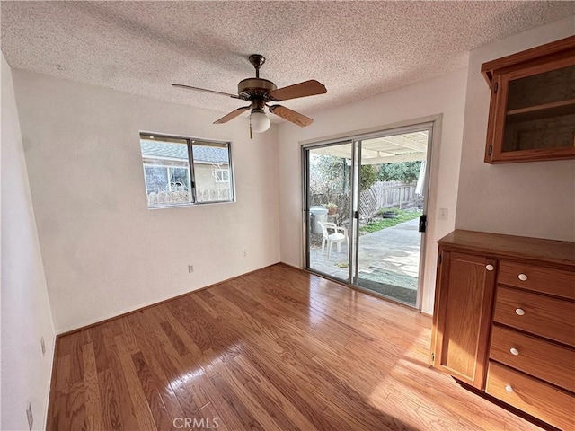 interior space featuring light wood-type flooring, ceiling fan, and a textured ceiling