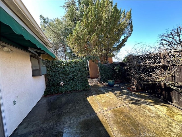 view of yard featuring fence and a patio