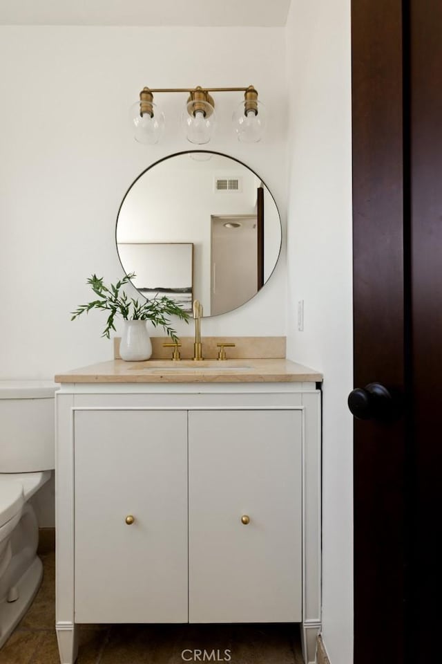 bathroom featuring visible vents, vanity, and toilet