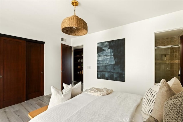 bedroom with light wood finished floors and visible vents