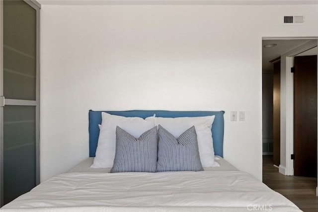 bedroom with visible vents and wood finished floors