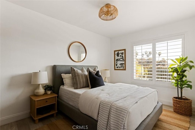 bedroom featuring wood finished floors and baseboards