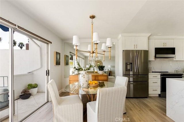 dining room featuring light wood-style flooring and an inviting chandelier