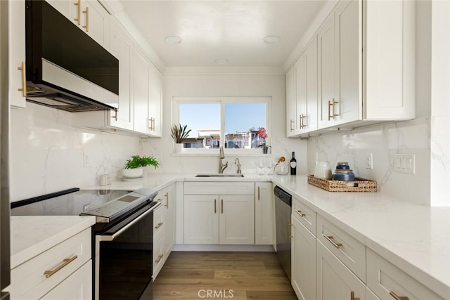 kitchen featuring dishwasher, range with electric stovetop, a sink, and white cabinetry