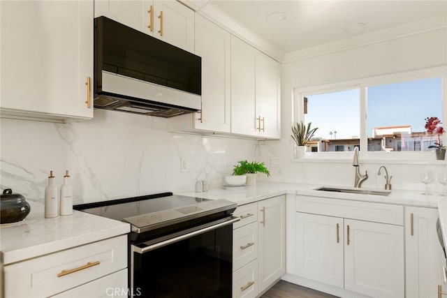 kitchen with electric range, stainless steel microwave, light stone counters, and white cabinets