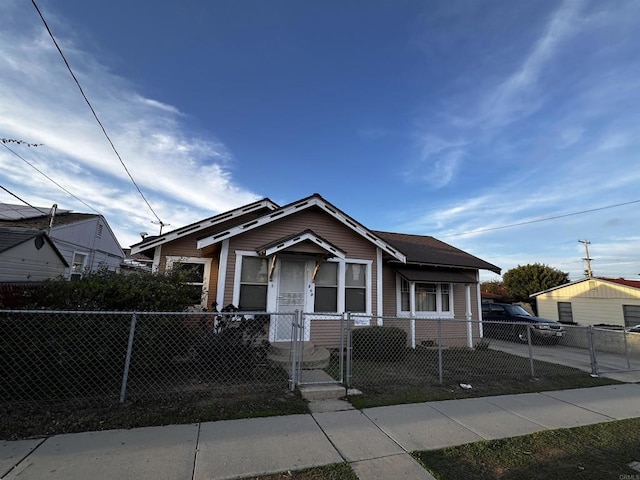 bungalow featuring a fenced front yard and a gate