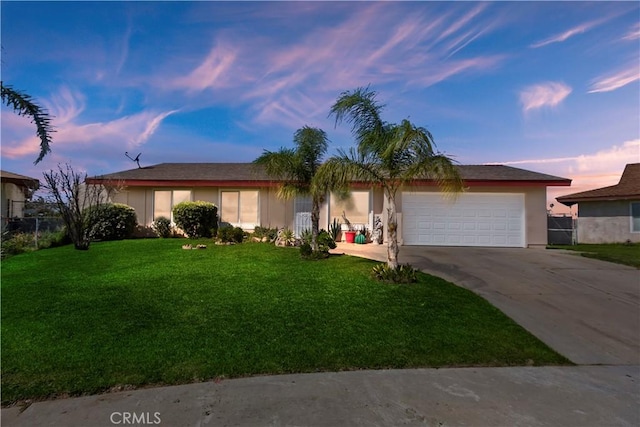 ranch-style house with driveway, a garage, a lawn, and stucco siding