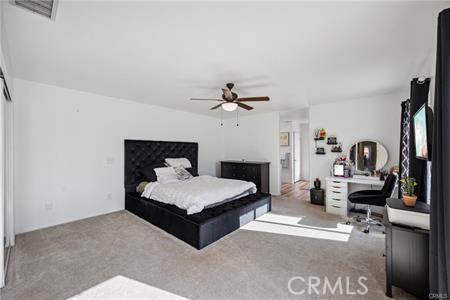 bedroom featuring light carpet, ceiling fan, and visible vents