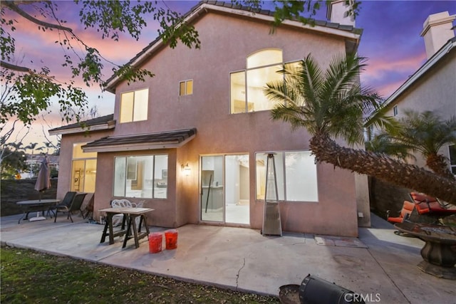 rear view of house with a patio area and stucco siding