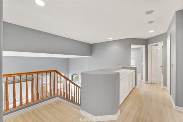 hall featuring light wood finished floors, recessed lighting, an upstairs landing, and baseboards