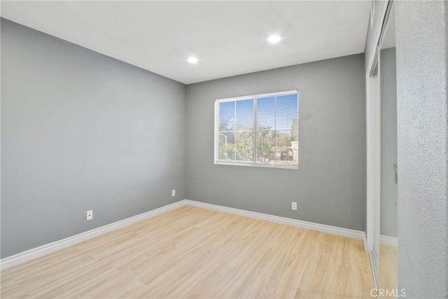 empty room featuring baseboards, recessed lighting, and light wood-style floors