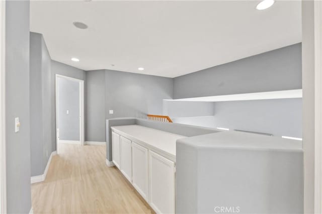 hall with light wood-style floors, recessed lighting, and baseboards