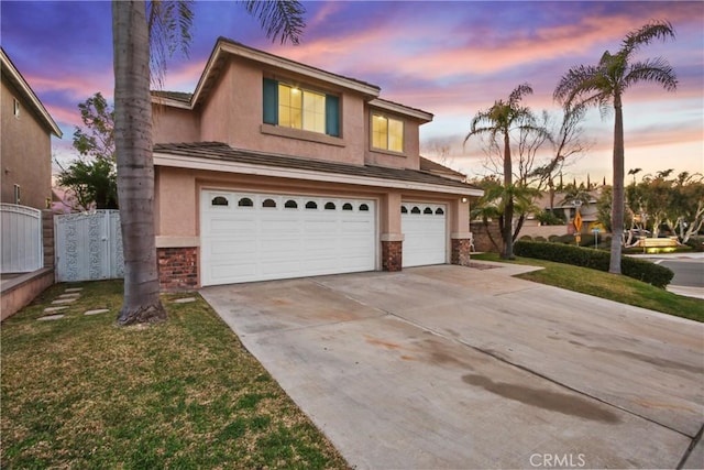 view of front of home featuring a garage, fence, driveway, a yard, and stucco siding