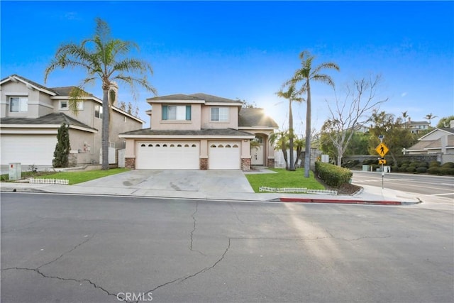 view of front of house with a garage, driveway, a residential view, and stucco siding