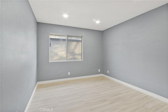 spare room with light wood finished floors, baseboards, and recessed lighting