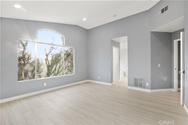 unfurnished room featuring light wood-style flooring, visible vents, and baseboards