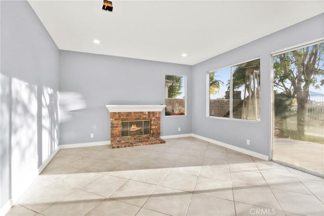 unfurnished living room with recessed lighting, a brick fireplace, baseboards, and light tile patterned floors