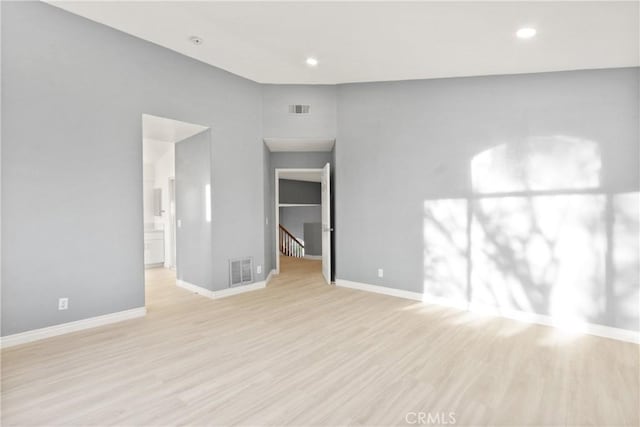 unfurnished room with light wood-style floors, baseboards, and visible vents