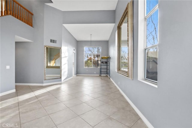 foyer entrance featuring a chandelier, light tile patterned flooring, visible vents, and baseboards