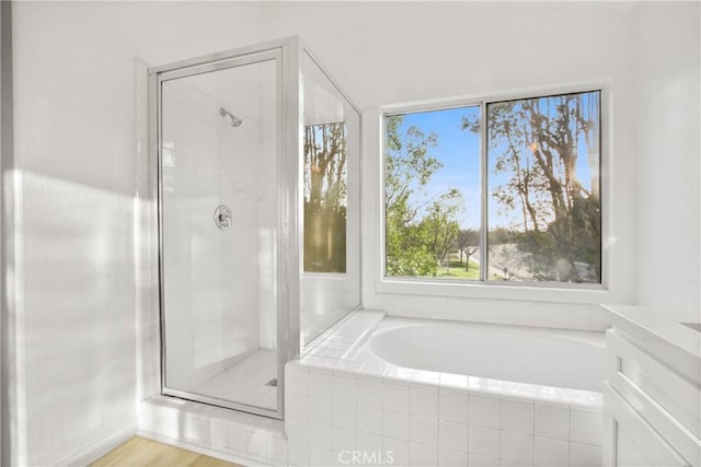 full bath with a stall shower and a garden tub