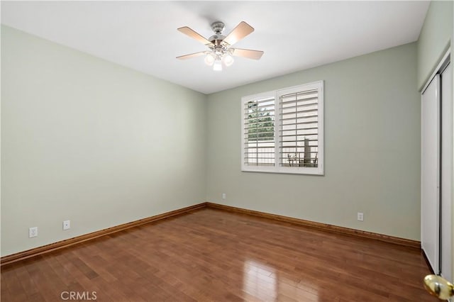 unfurnished bedroom with a ceiling fan, a closet, baseboards, and wood finished floors