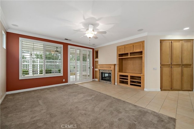 unfurnished living room featuring light tile patterned floors, visible vents, a tiled fireplace, light colored carpet, and ornamental molding