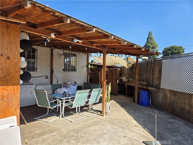 view of patio / terrace with washer / dryer, fence, and outdoor dining area