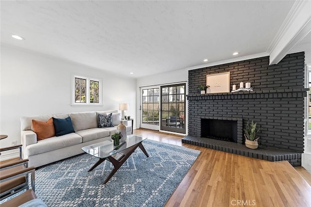 living area with crown molding, a fireplace, wood finished floors, and recessed lighting