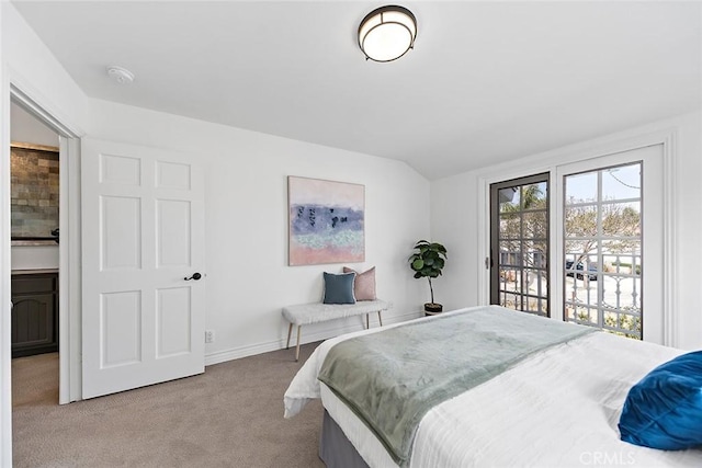 carpeted bedroom with vaulted ceiling and baseboards