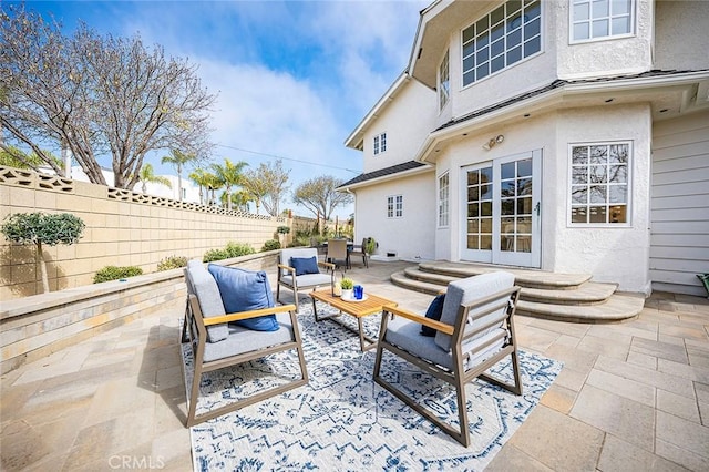 view of patio / terrace with entry steps, a fenced backyard, and an outdoor living space