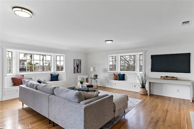 living area featuring light wood-type flooring and visible vents