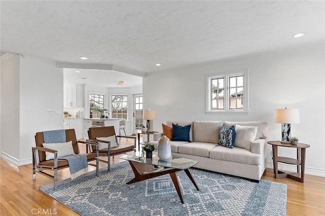 living room with light wood finished floors, baseboards, and a wealth of natural light